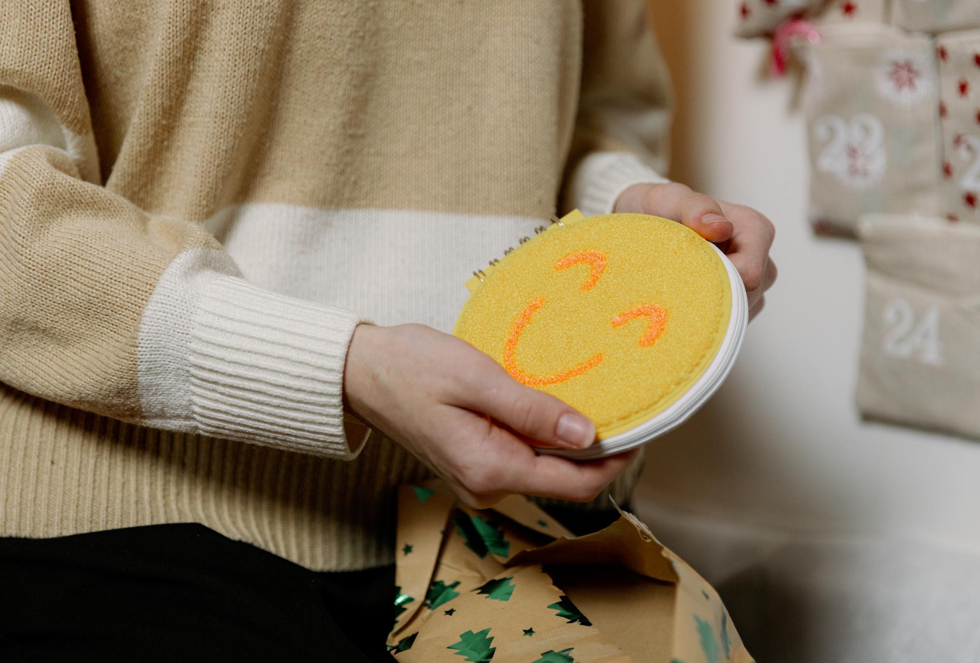 Hands holding embroidered patch